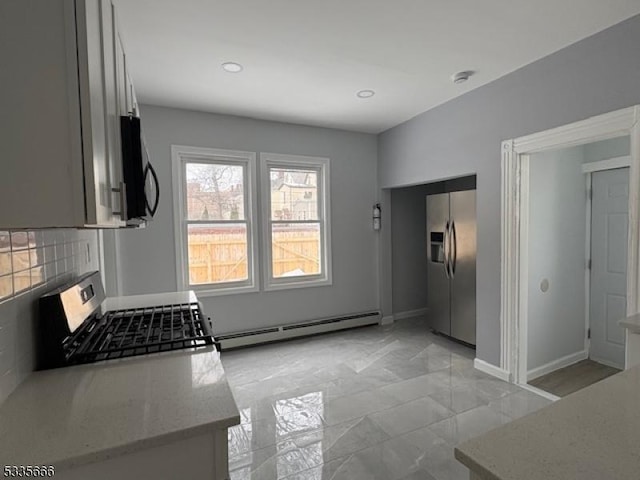 kitchen featuring stainless steel appliances, a baseboard radiator, backsplash, and light stone counters