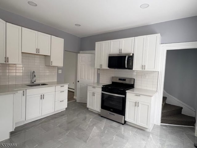 kitchen featuring white cabinetry, stainless steel appliances, sink, and tasteful backsplash