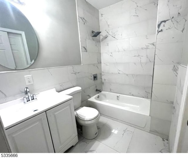 full bathroom featuring tiled shower / bath, tile walls, vanity, and toilet