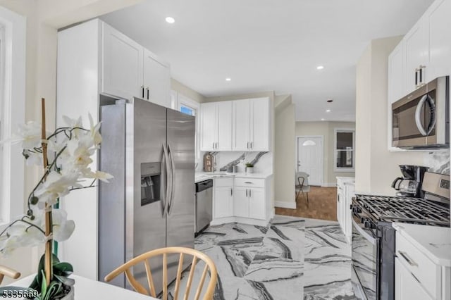 kitchen with tasteful backsplash, stainless steel appliances, and white cabinets