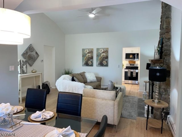 living room featuring vaulted ceiling, ceiling fan, and light wood finished floors