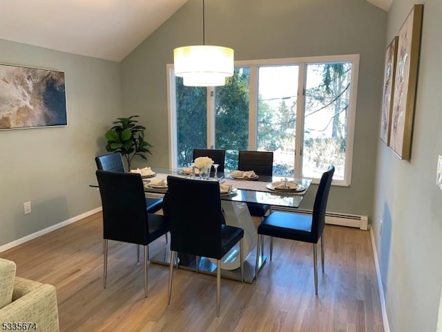 dining area with a wealth of natural light, vaulted ceiling, and wood finished floors