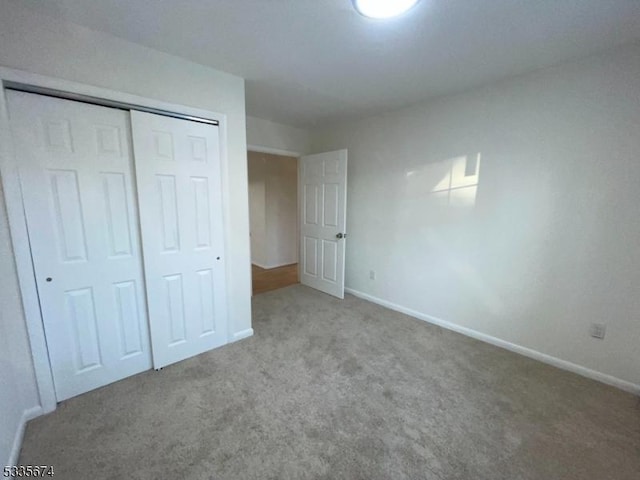 unfurnished bedroom featuring a closet, carpet, and baseboards