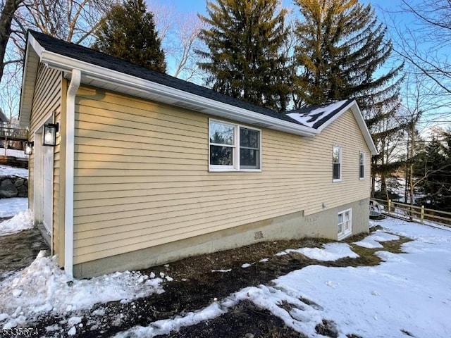 snow covered property with crawl space