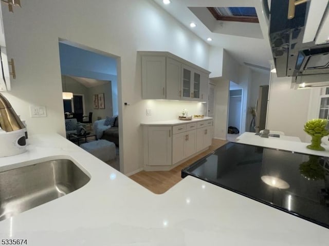 kitchen with recessed lighting, glass insert cabinets, light countertops, and range with electric stovetop