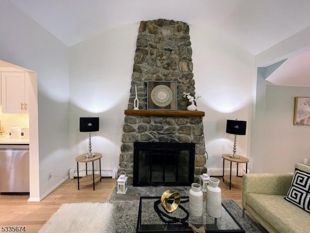 living room with a baseboard heating unit, light wood finished floors, a fireplace, and lofted ceiling