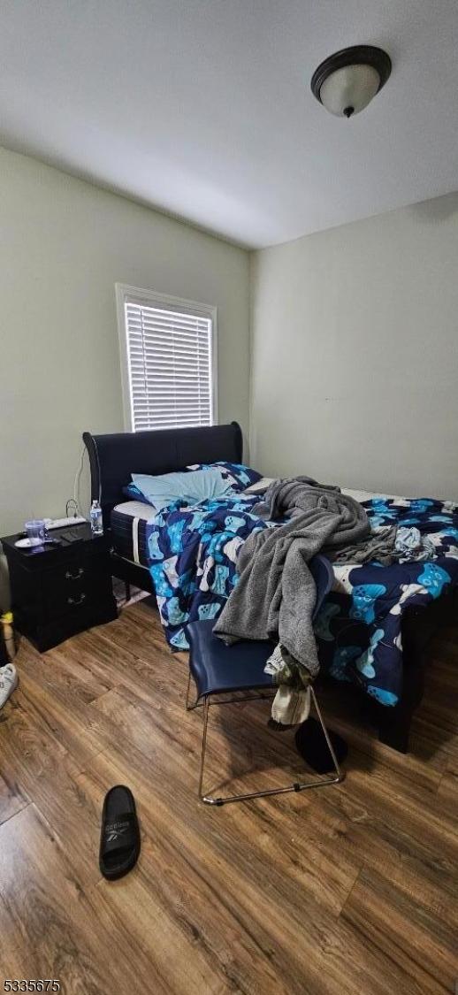 bedroom with dark hardwood / wood-style floors