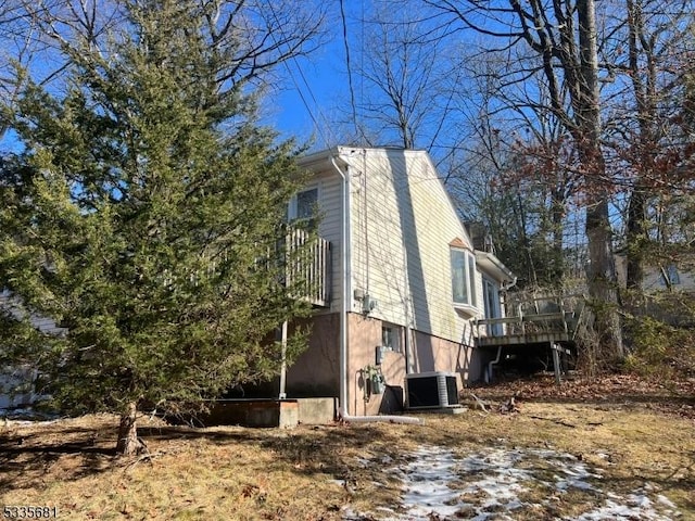 view of property exterior with cooling unit and a deck