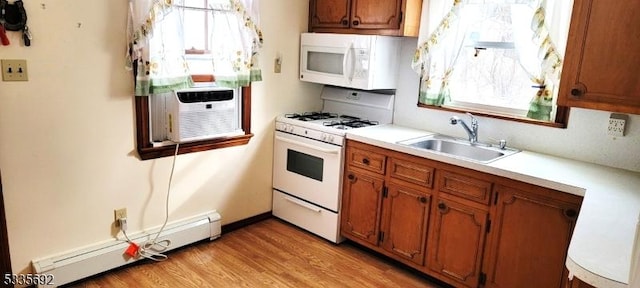 kitchen with sink, white appliances, cooling unit, light hardwood / wood-style floors, and a baseboard radiator