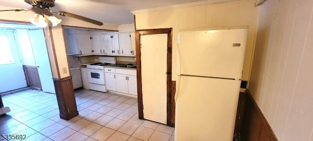 kitchen with white cabinetry, light tile patterned floors, ceiling fan, wooden walls, and white appliances