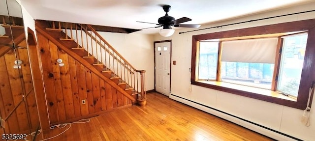 entrance foyer with baseboard heating, ceiling fan, plenty of natural light, and light hardwood / wood-style floors