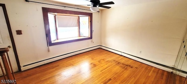 spare room with hardwood / wood-style flooring, a baseboard radiator, and ceiling fan