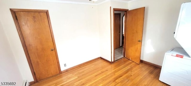 unfurnished bedroom with ornamental molding and light wood-type flooring