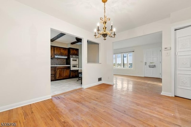 interior space with beamed ceiling, a notable chandelier, and light wood-type flooring