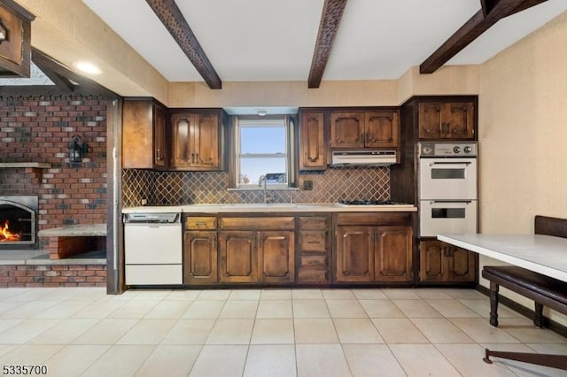 kitchen with beam ceiling, dark brown cabinets, white appliances, and decorative backsplash