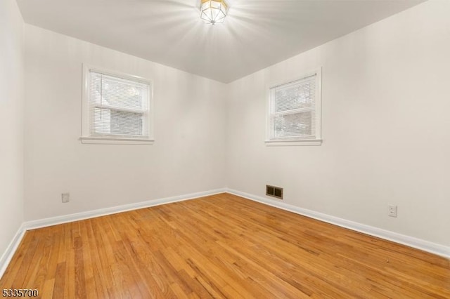 empty room featuring hardwood / wood-style flooring and a healthy amount of sunlight