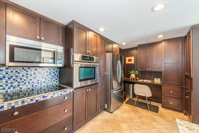 kitchen with backsplash, built in desk, and appliances with stainless steel finishes