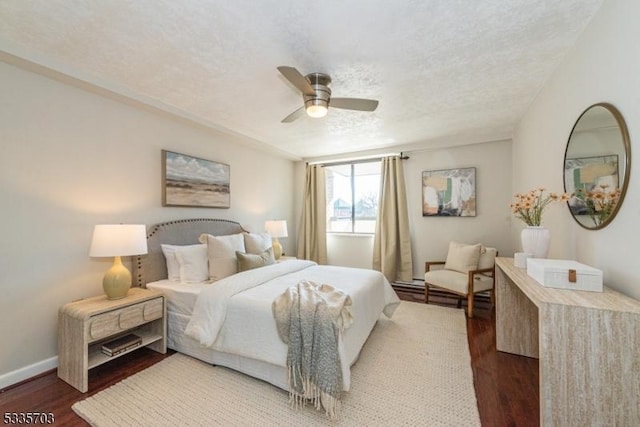 bedroom with ceiling fan, dark hardwood / wood-style floors, and a textured ceiling