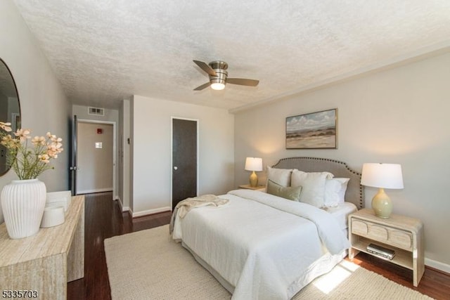 bedroom featuring ceiling fan, a textured ceiling, and dark hardwood / wood-style flooring