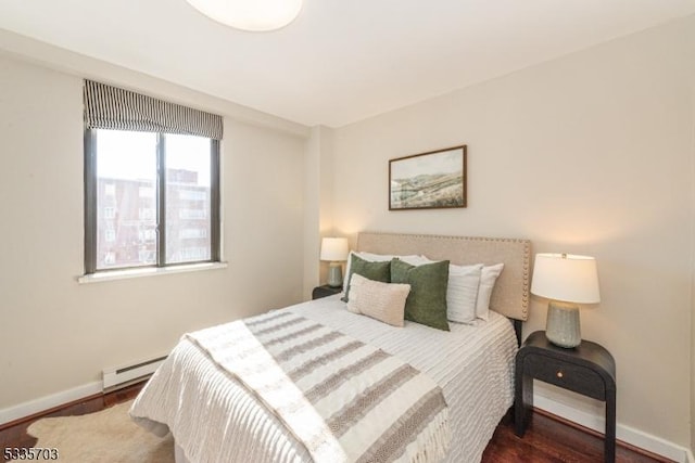 bedroom with dark hardwood / wood-style flooring and a baseboard radiator