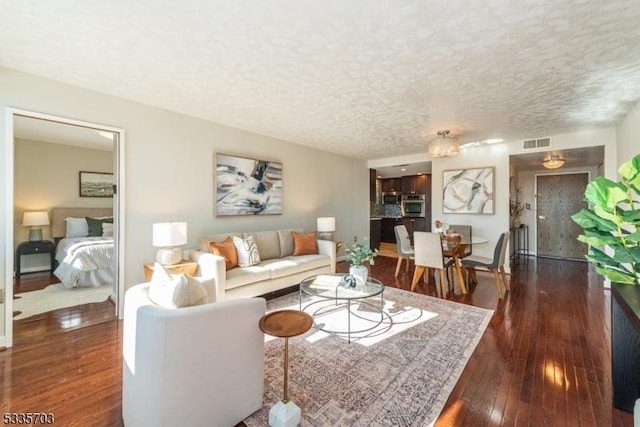 living room with dark hardwood / wood-style floors and a textured ceiling