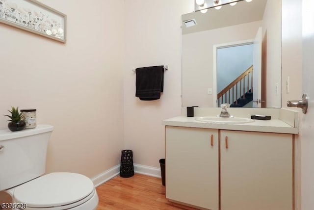 bathroom featuring vanity, toilet, and hardwood / wood-style floors