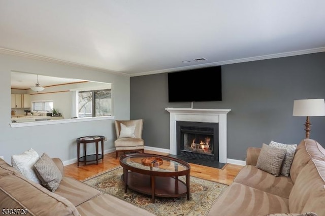 living room featuring ornamental molding and light wood-type flooring