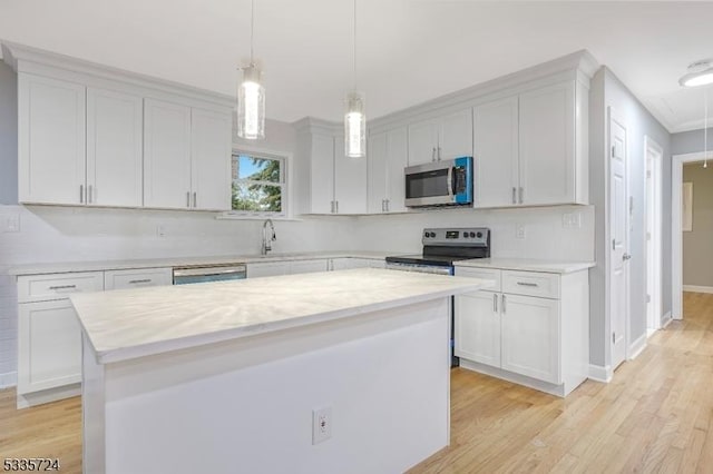 kitchen featuring stainless steel appliances, a kitchen island, and white cabinets