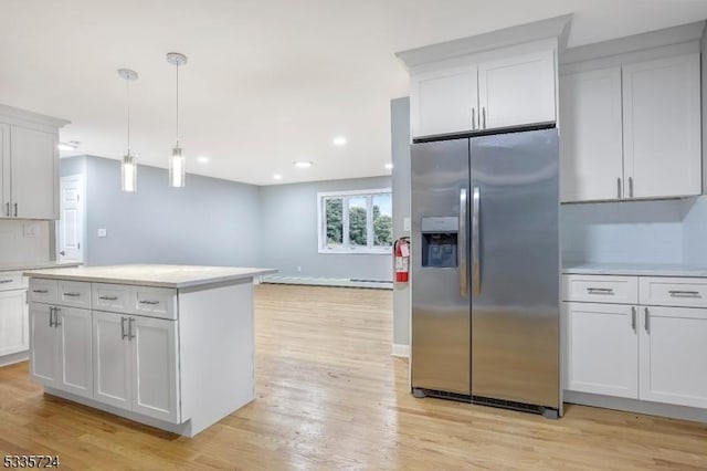 kitchen featuring hanging light fixtures, light hardwood / wood-style floors, white cabinets, and stainless steel refrigerator with ice dispenser