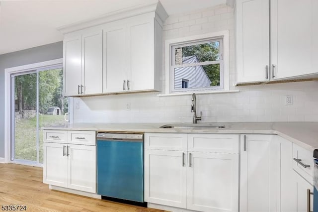 kitchen featuring sink, white cabinetry, dishwasher, light hardwood / wood-style floors, and decorative backsplash