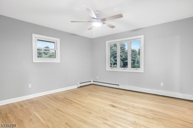 spare room featuring a baseboard heating unit, ceiling fan, and light hardwood / wood-style flooring