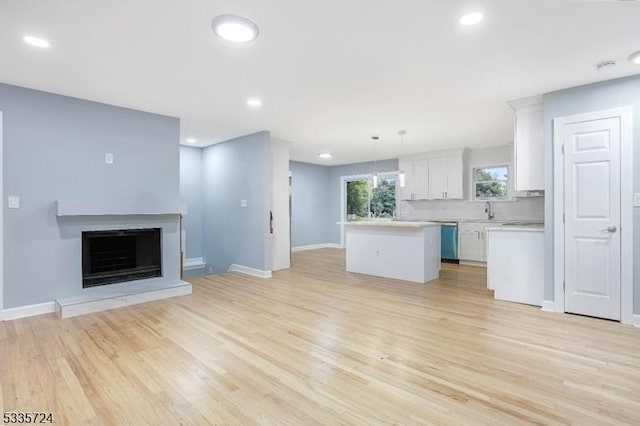 unfurnished living room featuring sink and light wood-type flooring