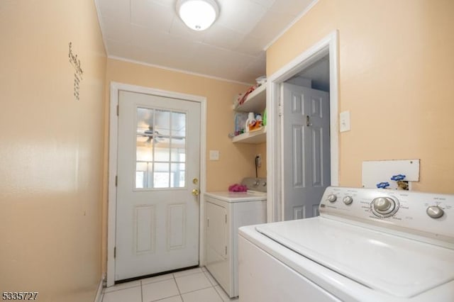 laundry room with crown molding, independent washer and dryer, and light tile patterned flooring