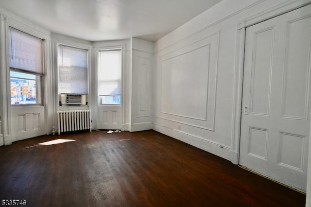 interior space featuring dark hardwood / wood-style flooring, radiator, and cooling unit