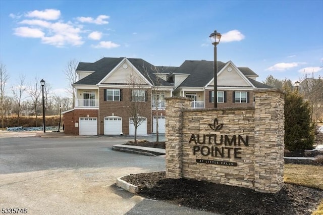 community sign with a garage and driveway