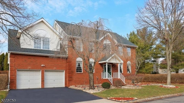 view of front of home featuring brick siding, driveway, an attached garage, and roof with shingles