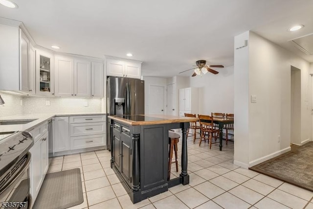 kitchen featuring range with electric cooktop, sink, white cabinets, and a breakfast bar