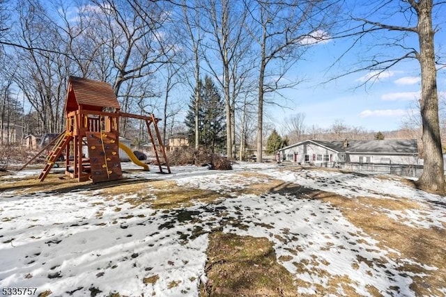 yard covered in snow featuring a playground