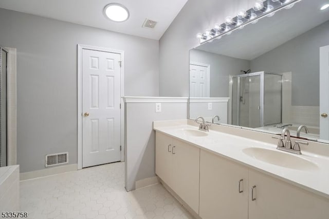 bathroom featuring a shower with door and vanity