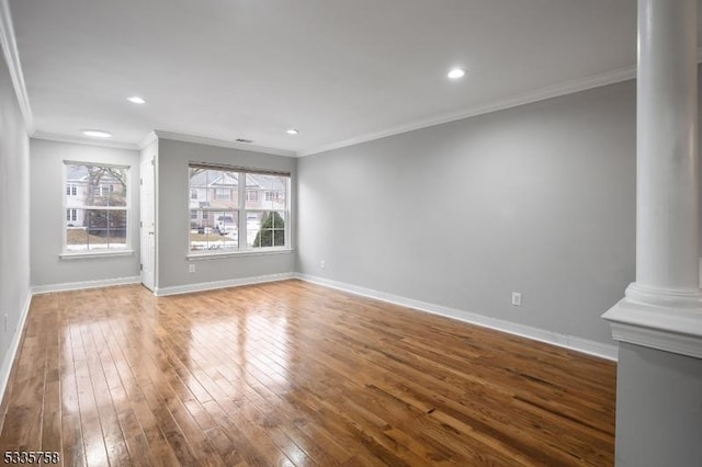 unfurnished living room featuring hardwood / wood-style flooring, crown molding, and decorative columns