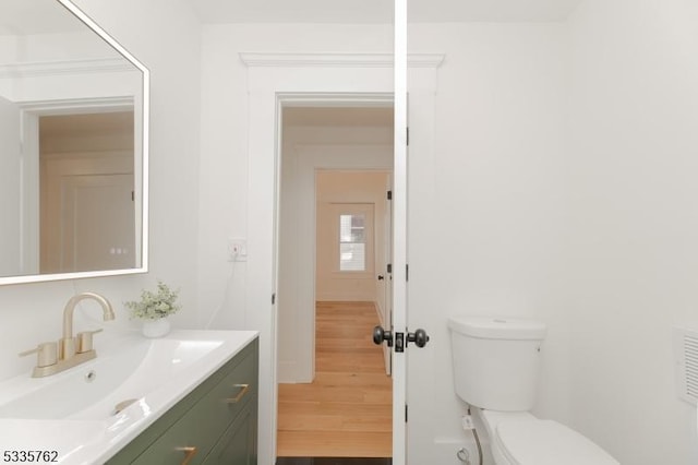 bathroom featuring vanity, toilet, and wood finished floors