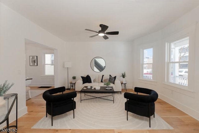 living room with light wood-type flooring, a healthy amount of sunlight, and baseboards