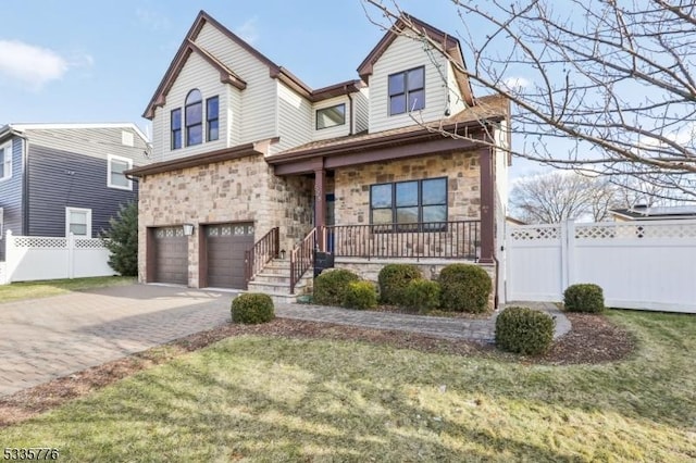 view of front of house with a garage, a front yard, and a porch