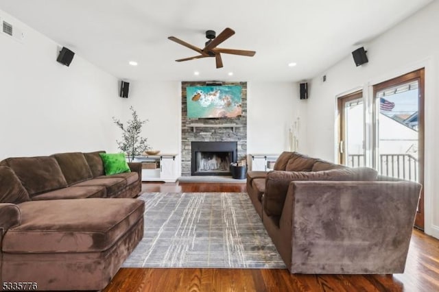 living room featuring ceiling fan, a fireplace, and hardwood / wood-style floors