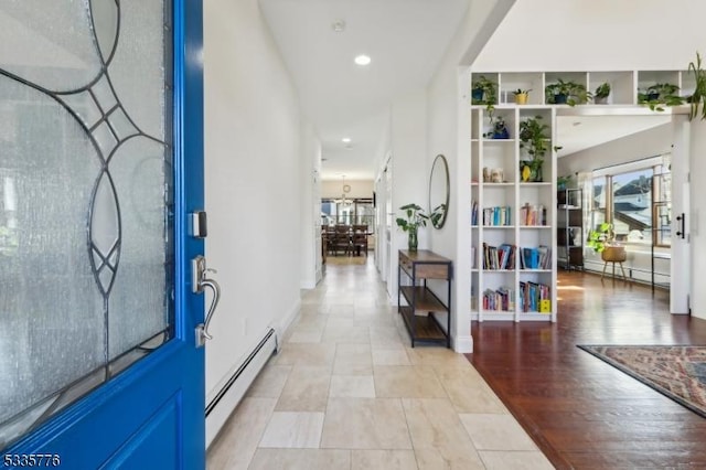 foyer featuring light wood-type flooring, a wealth of natural light, and baseboard heating