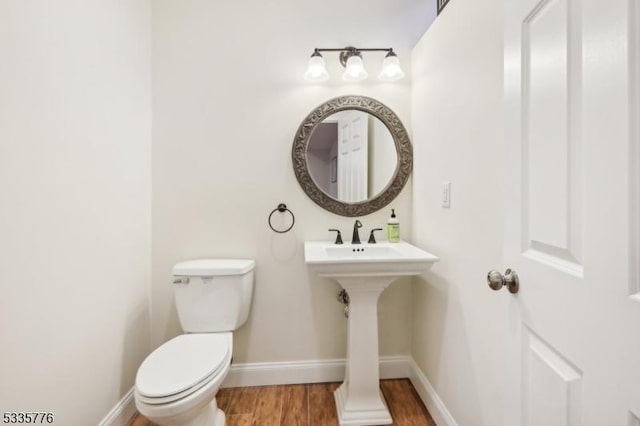 bathroom featuring wood-type flooring and toilet