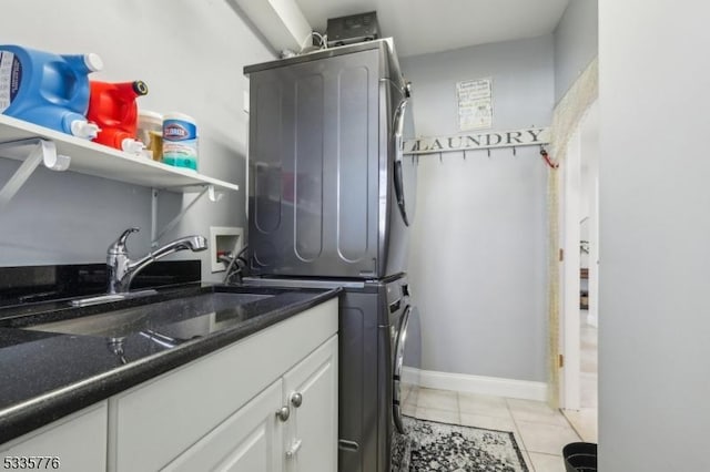 washroom with cabinets, stacked washer and clothes dryer, sink, and light tile patterned floors