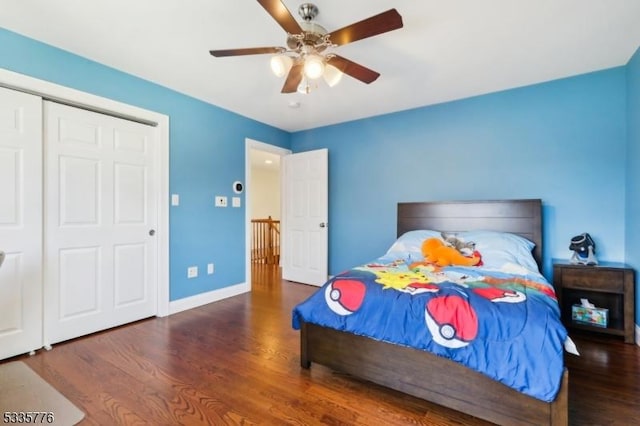 bedroom with dark wood-type flooring, ceiling fan, and a closet