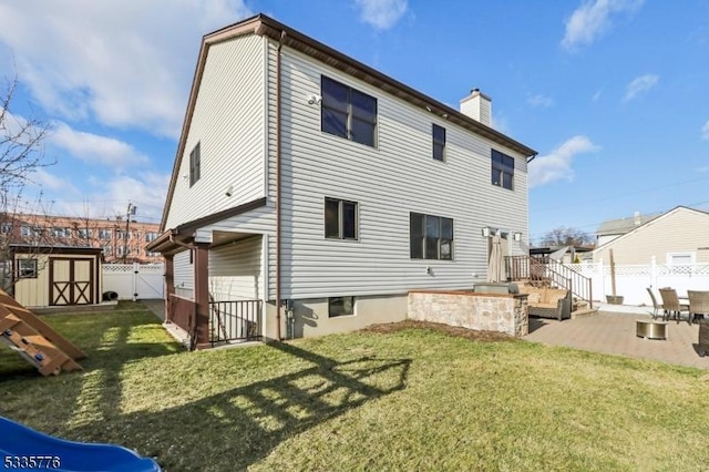 rear view of property with a yard, a shed, and a patio area