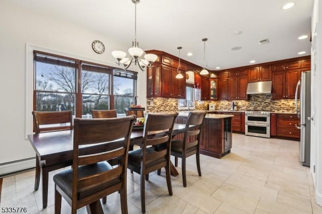 kitchen featuring an inviting chandelier, backsplash, decorative light fixtures, and appliances with stainless steel finishes